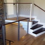 indoor stairs with protective metal cable rails and fence